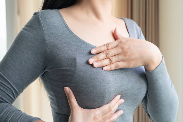 woman hand checking lumps on her breast for signs of breast cancer. women healthcare concept. - beleza doentes cancro imagens e fotografias de stock