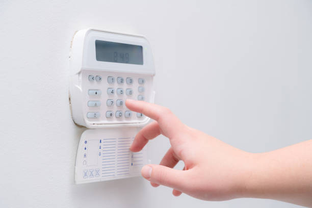 Woman hand entering alarm system password of an apartment, house of business office. Surveillance and protection console against rubbery and thief Woman hand entering alarm system password of an apartment, house of business office. Surveillance and protection console against rubbery and thief burglar alarm stock pictures, royalty-free photos & images