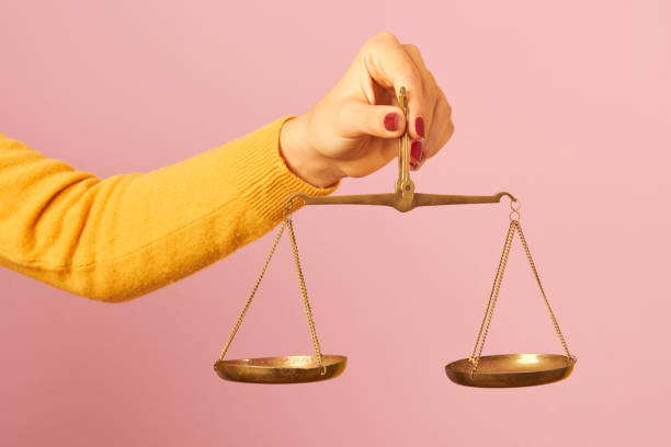 woman hand holding a balance woman hand holding a balance on pink background choosing an lawyer stock pictures, royalty-free photos & images