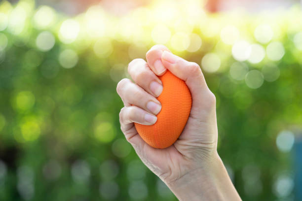 woman hand holding stress ball on nature background stock photo