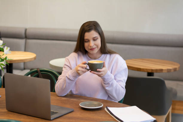 femme tenant la main avec mousse mousse art dans une tasse en céramique grise buvant du café dans un café - ouvrier coeur photos et images de collection