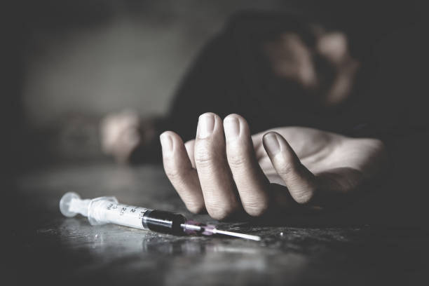 Woman hand of a drug addict and a syringe with narcotic syringe lying on the floor, Overdose, drug concept. Woman hand of a drug addict and a syringe with narcotic syringe lying on the floor, Overdose, drug concept. heroin stock pictures, royalty-free photos & images