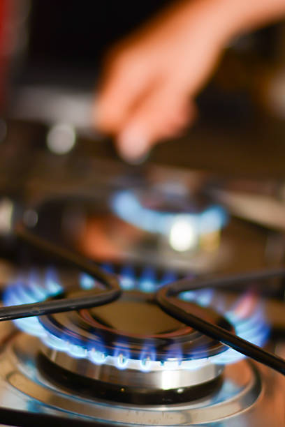 Woman hand opening a gas flame stove Woman hand opening a gas flame stove camping stove stock pictures, royalty-free photos & images