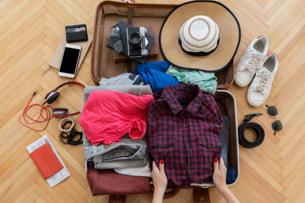 vrouw voorbereiden zomer handbagage - packing suitcase stockfoto's en -beelden