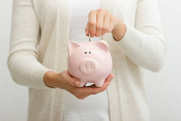 mujer a mano poniendo moneda de dinero en piggy para ahorrar dinero riqueza y concepto financiero. - piggy bank fotografías e imágenes de stock