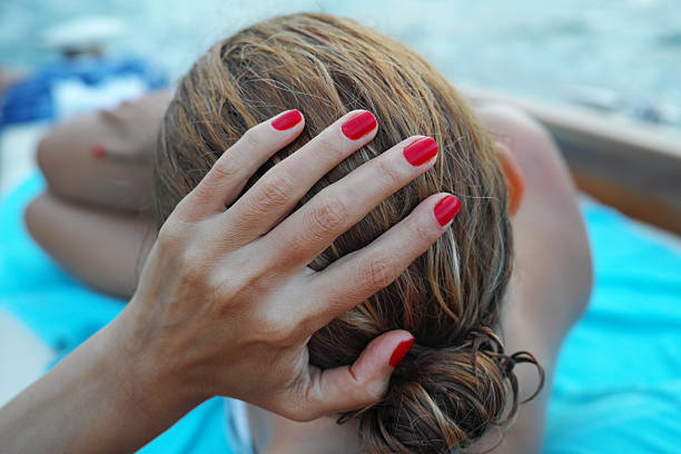 Woman Hand Red Nail Polish In Summer stock photo