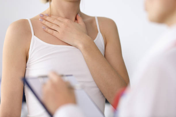 Woman hand showing sore neck at doctor appointment closeup stock photo