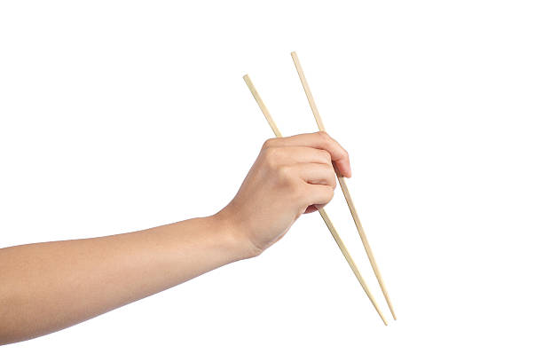 Woman hand using a chopsticks Woman hand using a chopsticks isolated on a white background chopsticks stock pictures, royalty-free photos & images