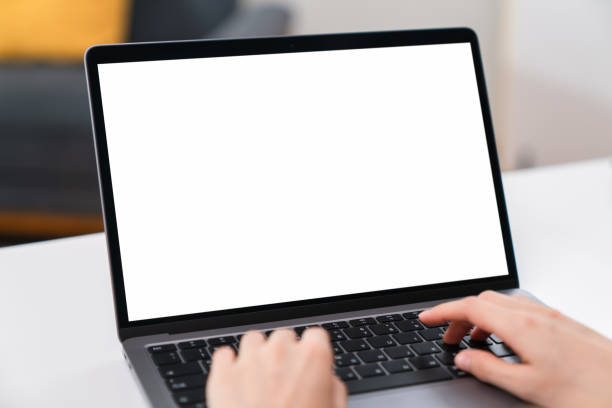 Woman hand using laptop and sitting on the table in the house, mock-up of a blank screen for the application. stock photo