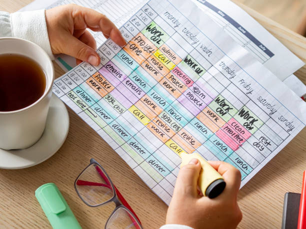 Woman hands holding a Time blocking weekly calendar to organize stock photo