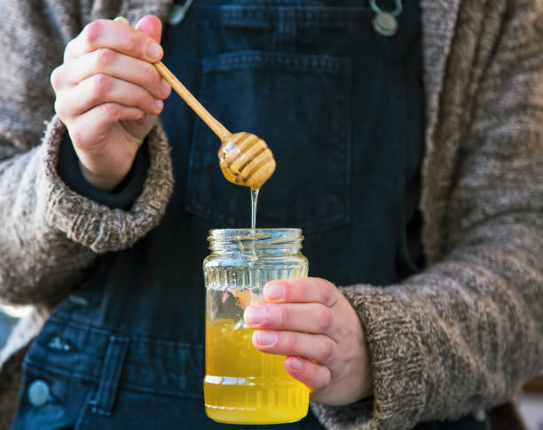 Woman hands holding raw organic honey jar stock photo