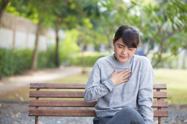 Woman has reflux acids at park stock photo