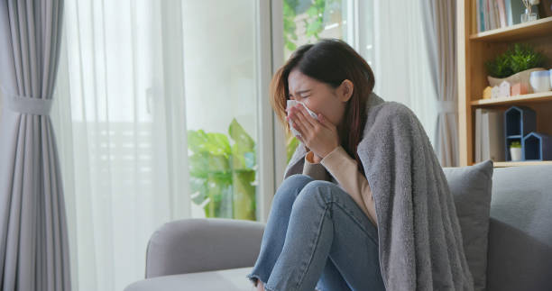woman has running nose sick asian woman is blowing running nose and sneezing in tissue at home uncomfortable photos stock pictures, royalty-free photos & images