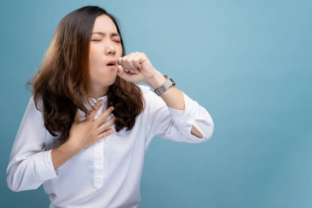 Woman has sore throat isolated over blue background stock photo