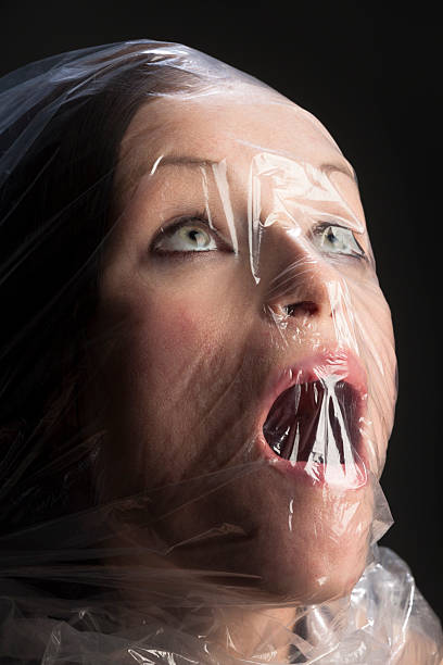 woman-having-nightmare-of-being-suffocated-with-plastic-bag-picture-id175172770