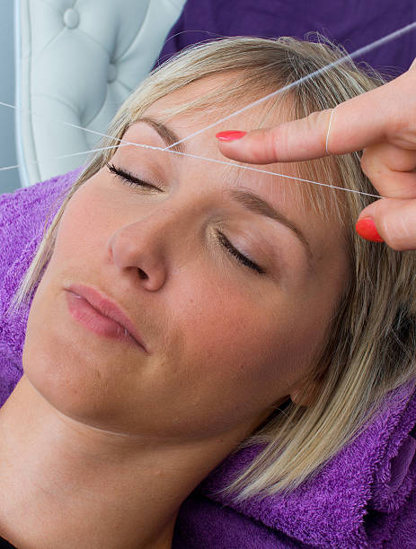 woman having threading hair removal procedure stock photo