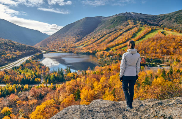 Woman hiking at Artist's Bluff in autumn Woman hiking at Artist's Bluff in autumn. View of Echo Lake. Fall colours in Franconia Notch State Park. White Mountain National Forest, New Hampshire, USA state park stock pictures, royalty-free photos & images