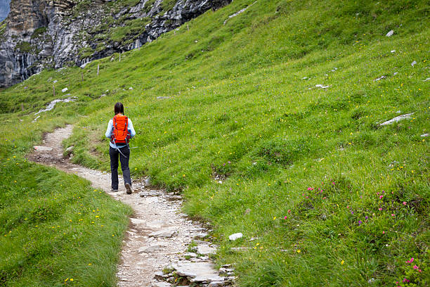 Woman Hiking on Winding Mountain Path stock photo