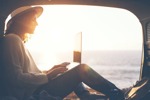 woman hipster using laptop in the car stock photo