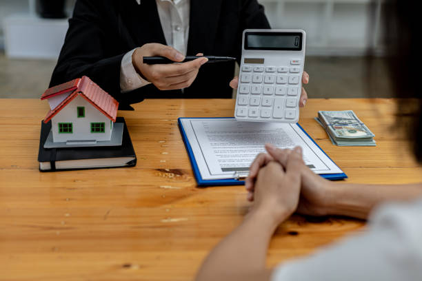 Woman holding a calculator. The housing salesman is looking to pay off the mortgage for interested clients to come and see the home projects she takes care of. Real estate trading ideas. stock photo