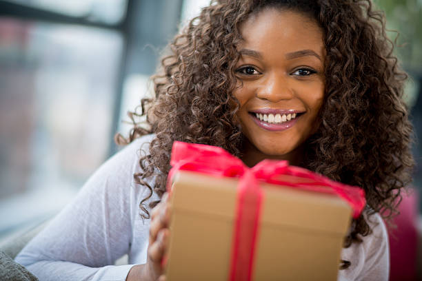 mulher segurando um presente - woman holding a christmas gift imagens e fotografias de stock