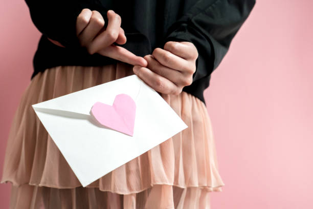 Woman holding a love letter Woman holding a love letter. shy japanese woman stock pictures, royalty-free photos & images