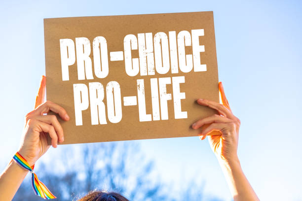 una mujer sosteniendo un cartel en sus manos a favor de la legalización del aborto. protesta para no ilegalizar el aborto en los estados unidos, pro-elección, pro-vida - abortion clinic fotografías e imágenes de stock