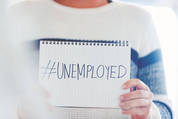 Woman holding a #unemployed sign written on a pad Woman holding a #unemployed sign written on a pad. Human resources, recession or economic depression concept downsizing unemployment stock pictures, royalty-free photos & images