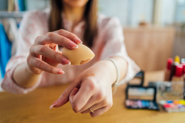 Woman holding beauty blender sponge Woman holding beauty blender sponge with foundation on him. Makeup, beauty concept. foundation stock pictures, royalty-free photos & images