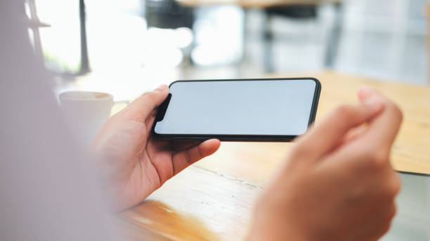 Woman holding blank screen smartphone. Closeup of woman holding blank screen smartphone. Copy space and mockup. horizontal stock pictures, royalty-free photos & images