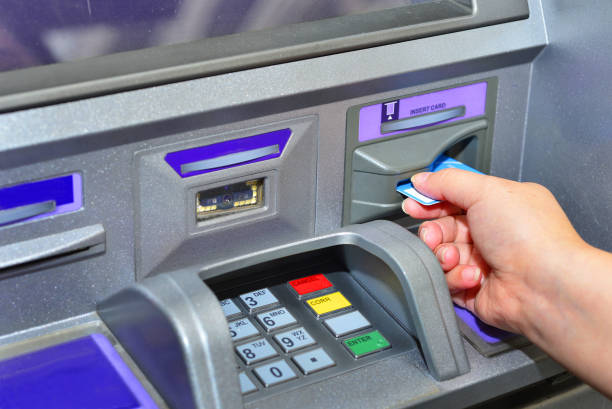 Woman holding card ,using ATM Woman using her credit card on ATM machine banks and atms stock pictures, royalty-free photos & images