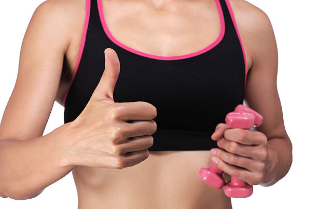 woman holding dumbbells doing the okay sign stock photo