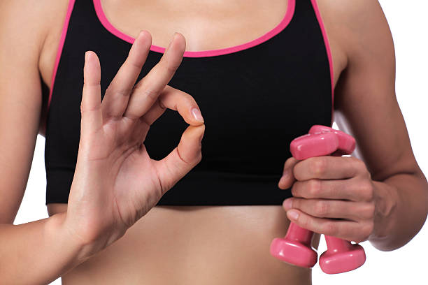 woman holding dumbbells making the sign all is well stock photo