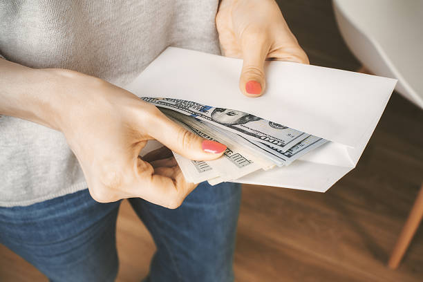 Woman holding envelope with dollars stock photo
