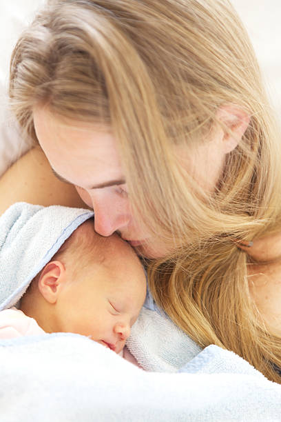 woman holding her sleeping 2 days old daughter. stock photo
