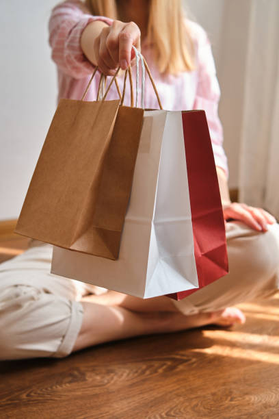 woman holding in hand shopping package. paper bag. sale in store. beautiful young girl after shopping in fashion shop. customer buy present online. black friday sale. holiday special offer, discount - paper bag craft imagens e fotografias de stock