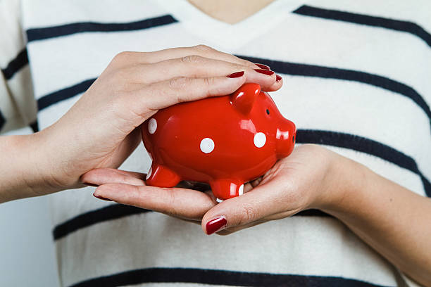 Woman holding red piggy bank stock photo