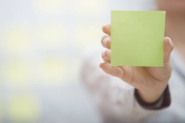 Woman holding sticky note with empty space stock photo