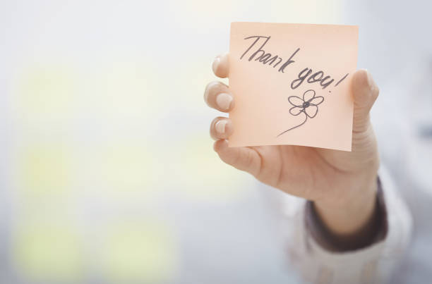 Woman holding sticky note with Thank you text stock photo
