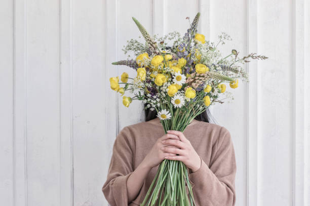 woman holding wild yellow flower bouquet woman holding wild yellow flower bouquet beautiful swedish women stock pictures, royalty-free photos & images