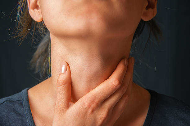 Woman holds her throat, sore throat stock photo