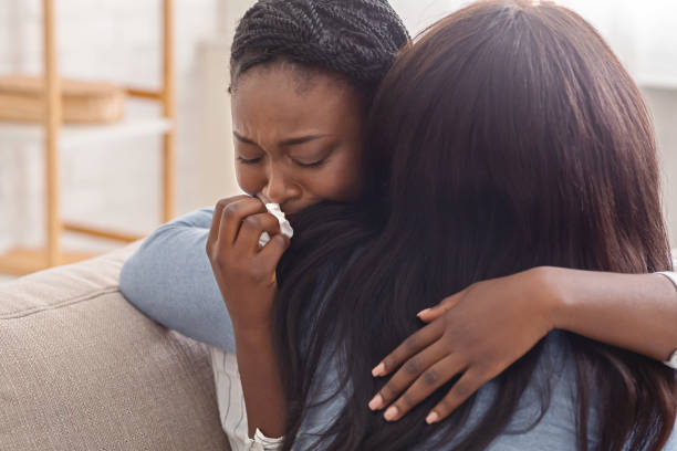 Woman hugging her crying girlfriend, supporting her after receiving bad news Condolence and support concept. Caring woman hugging her crying black girlfriend, comforting her after receiving bad news grief stock pictures, royalty-free photos & images