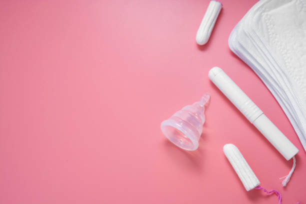 de hygiëneproducten van de vrouw, menstruatie, katoentampons, maandverband, menstruele kop voor vrouwenkritieke dagen. roze achtergrond met exemplaarruimte. - menstruatie stockfoto's en -beelden