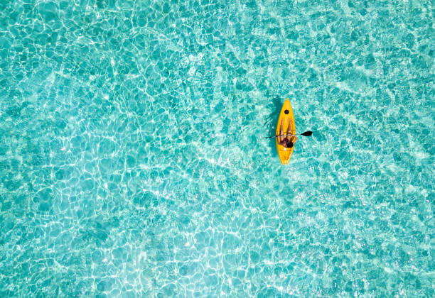 woman in a canoe over turquoise, tropical waters - aerial boat imagens e fotografias de stock