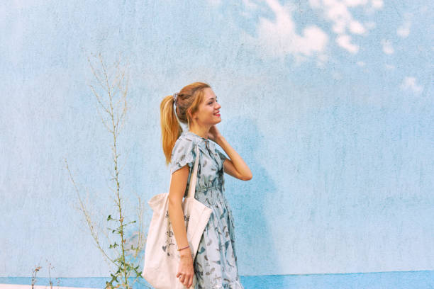 Woman in a dress near the wall stock photo