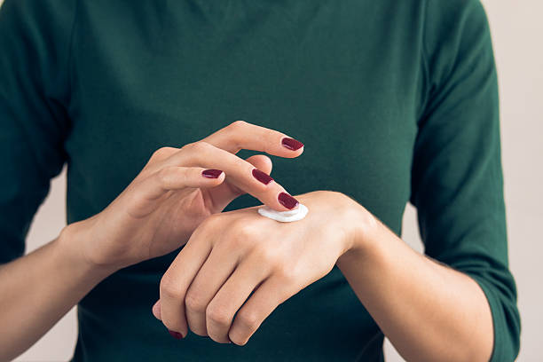 Woman in a green T-shirt and a maroon manicure stock photo