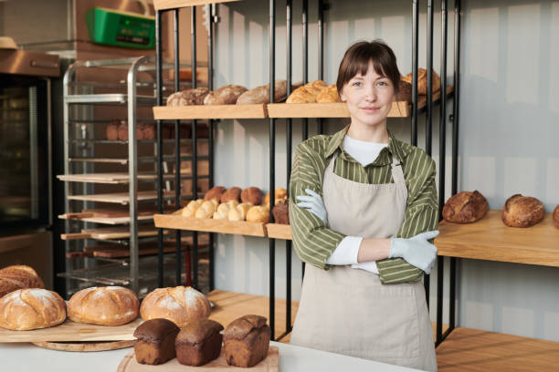 Woman in apron working in bakery stock photo