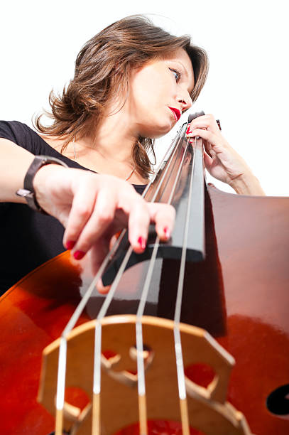 Woman in black dress play double bass. Low point view stock photo
