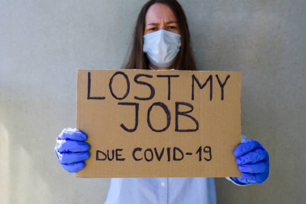 Woman in face mask and gloves with cardboard sign LOST JOB Woman office worker in blue shirt with cardboard sign LOST JOB. Jobless, unemployment due covid-19 concept. Asking for money downsizing unemployment stock pictures, royalty-free photos & images