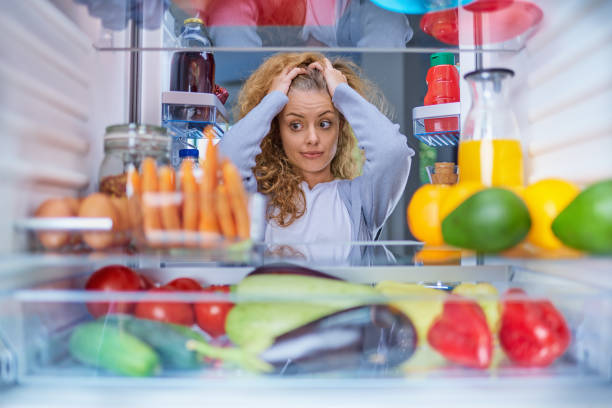 Woman in front of fridge. stock photo